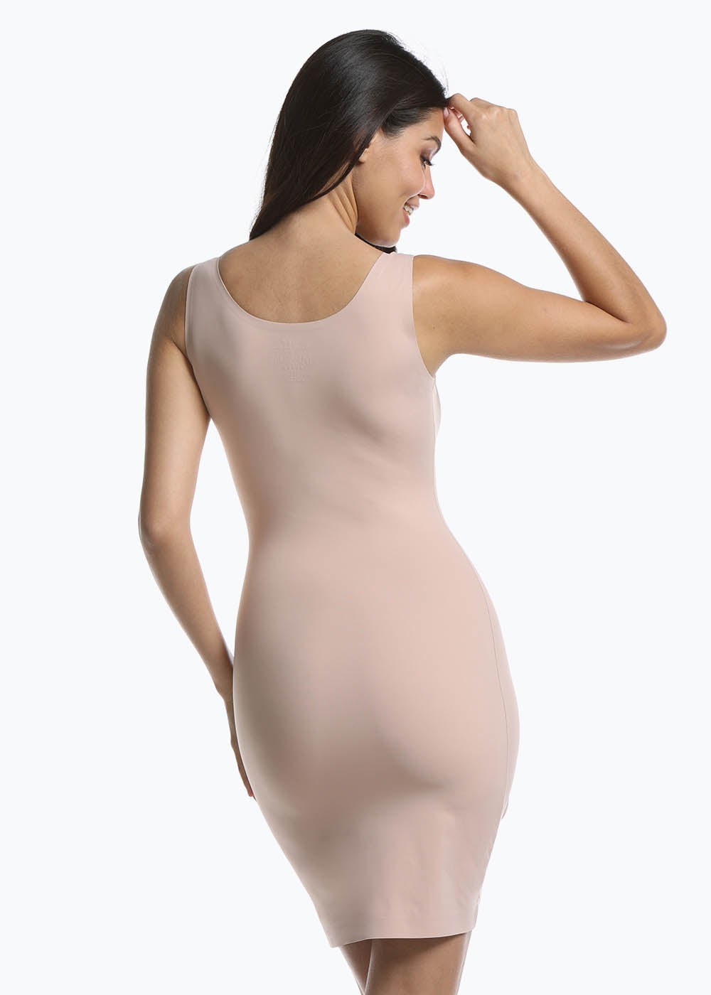 Back view of a model wearing Tone Your Body Dress in cappuccino, body-contouring tank dress. Smooth powerful recycled fabric providing firm shaping for back, hips, and legs, with seamless edges, smooth shoulders, and silicone-lined leg openings visible.