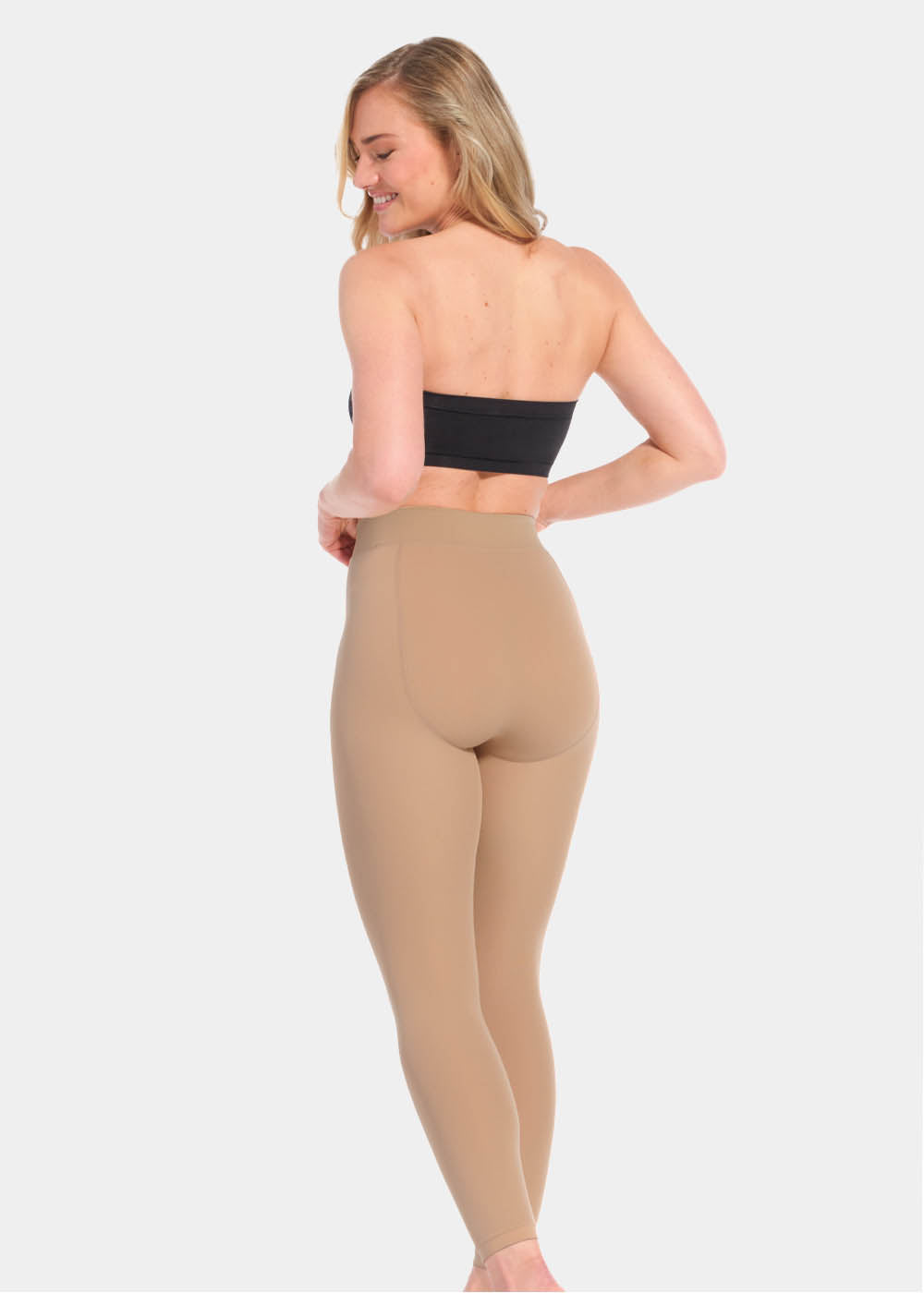 Back view of a model wearing Warm Fleece-Lined MAGIC Leggings in sunshine, high-waist fleece-lined leggings. Smooth fabric providing medium shaping for lower back and tummy, ladder-resistant finish, and translucent-look legs visible.