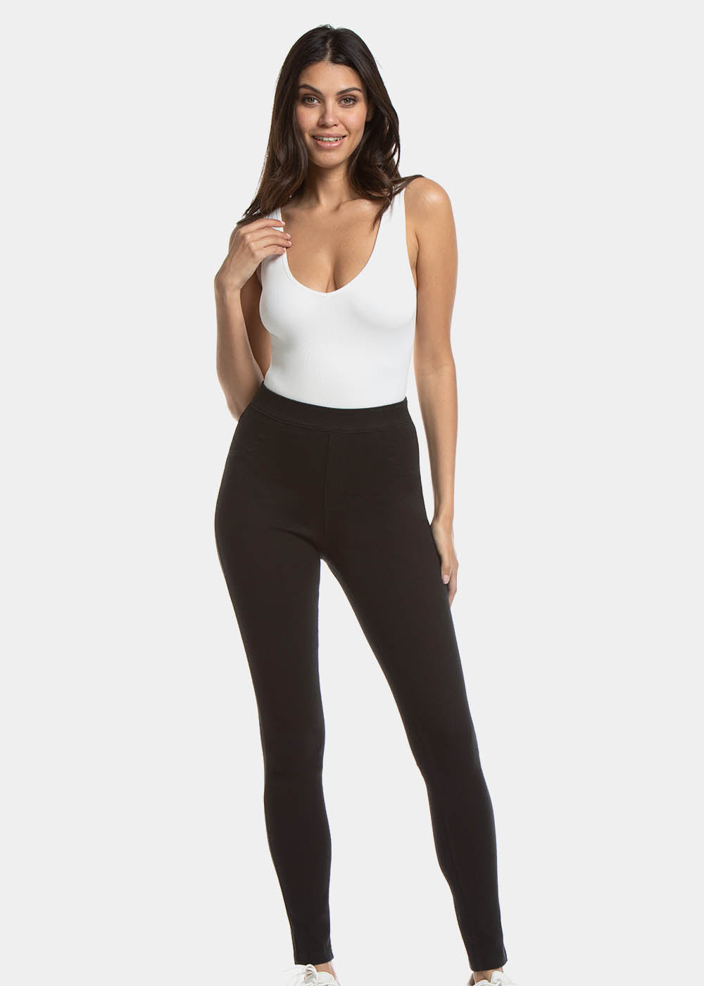 Front view of a model wearing Jegging in black, high-waist skinny-fit leggings with built-in shaping briefs. Soft stretchy fabric providing medium shaping for tummy, hips, and back, with cotton gusset, lifted bottom zone, and faux front and functional back pockets visible.