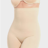A woman wearing a high-waisted black shapewear Bermuda that extends to mid-thigh.