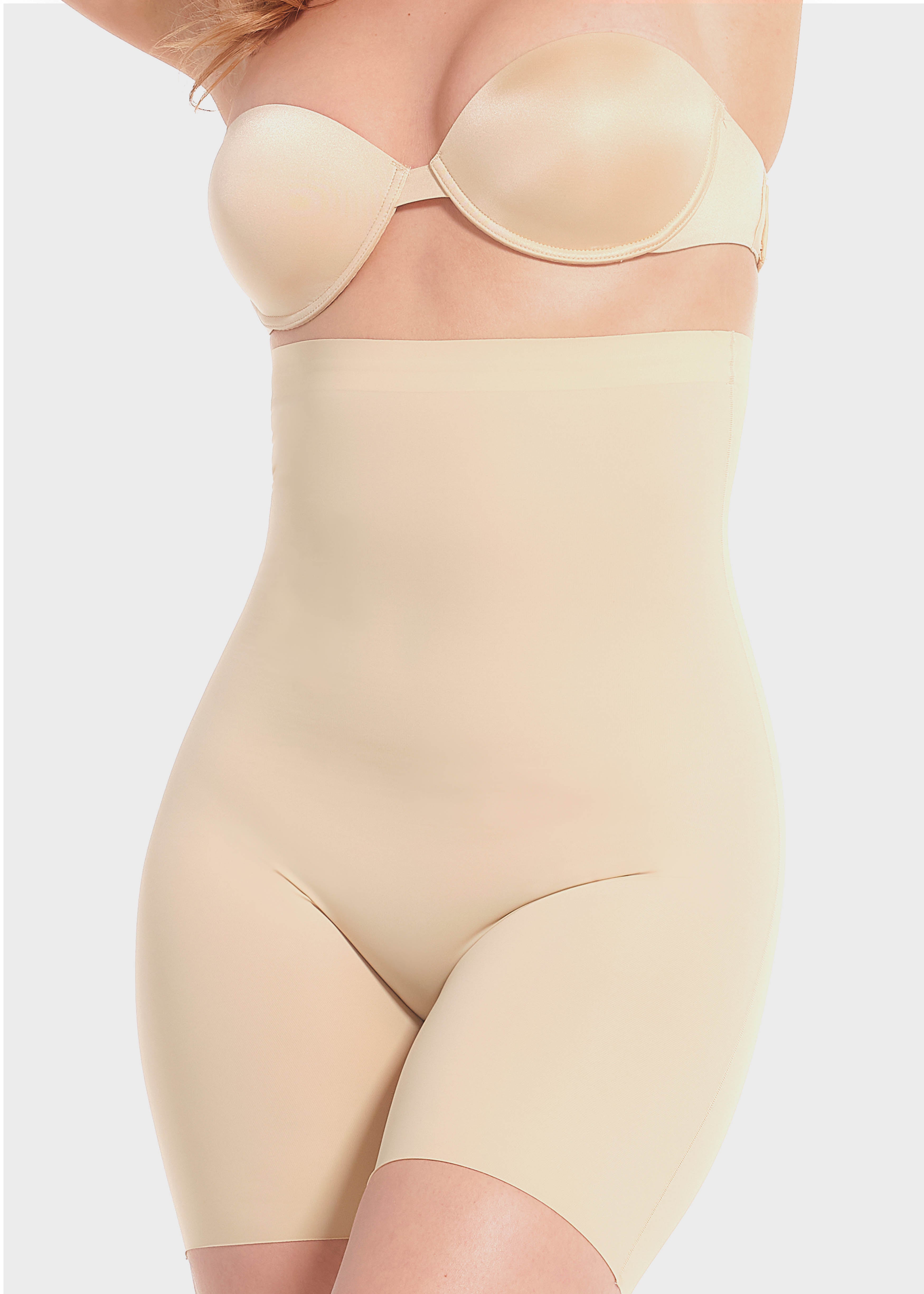 A woman wearing a high-waisted black shapewear Bermuda that extends to mid-thigh.
