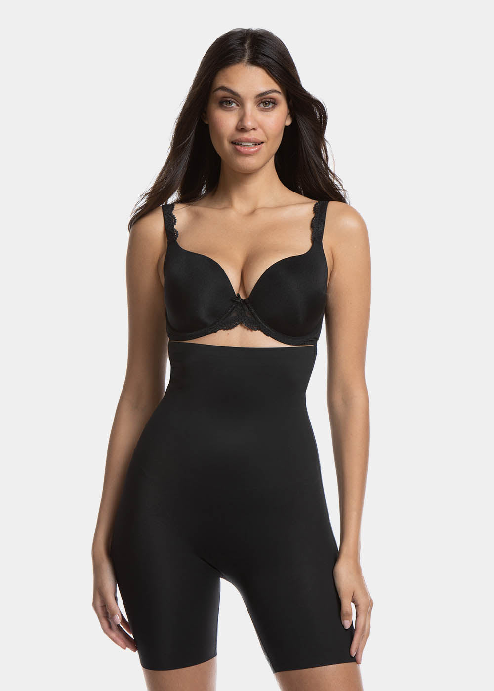 A woman wearing a high-waisted black shapewear Bermuda that extends to mid-thigh.