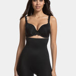 A woman wearing a high-waisted black shapewear Bermuda that extends to mid-thigh.