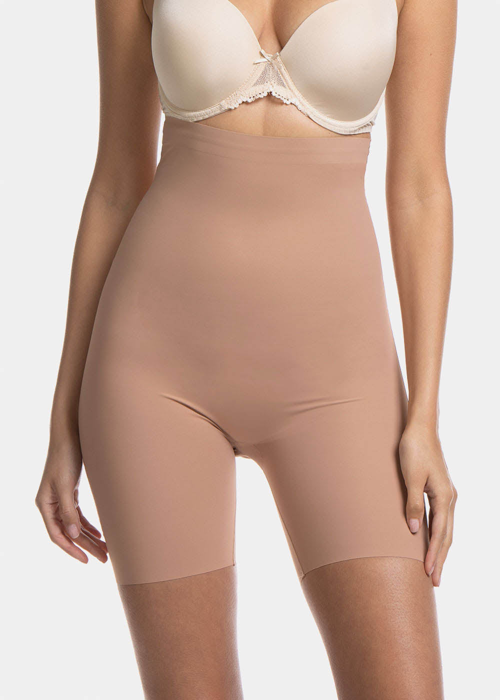 A woman wearing a high-waisted black shapewear Bermuda that extends to mid-thigh.