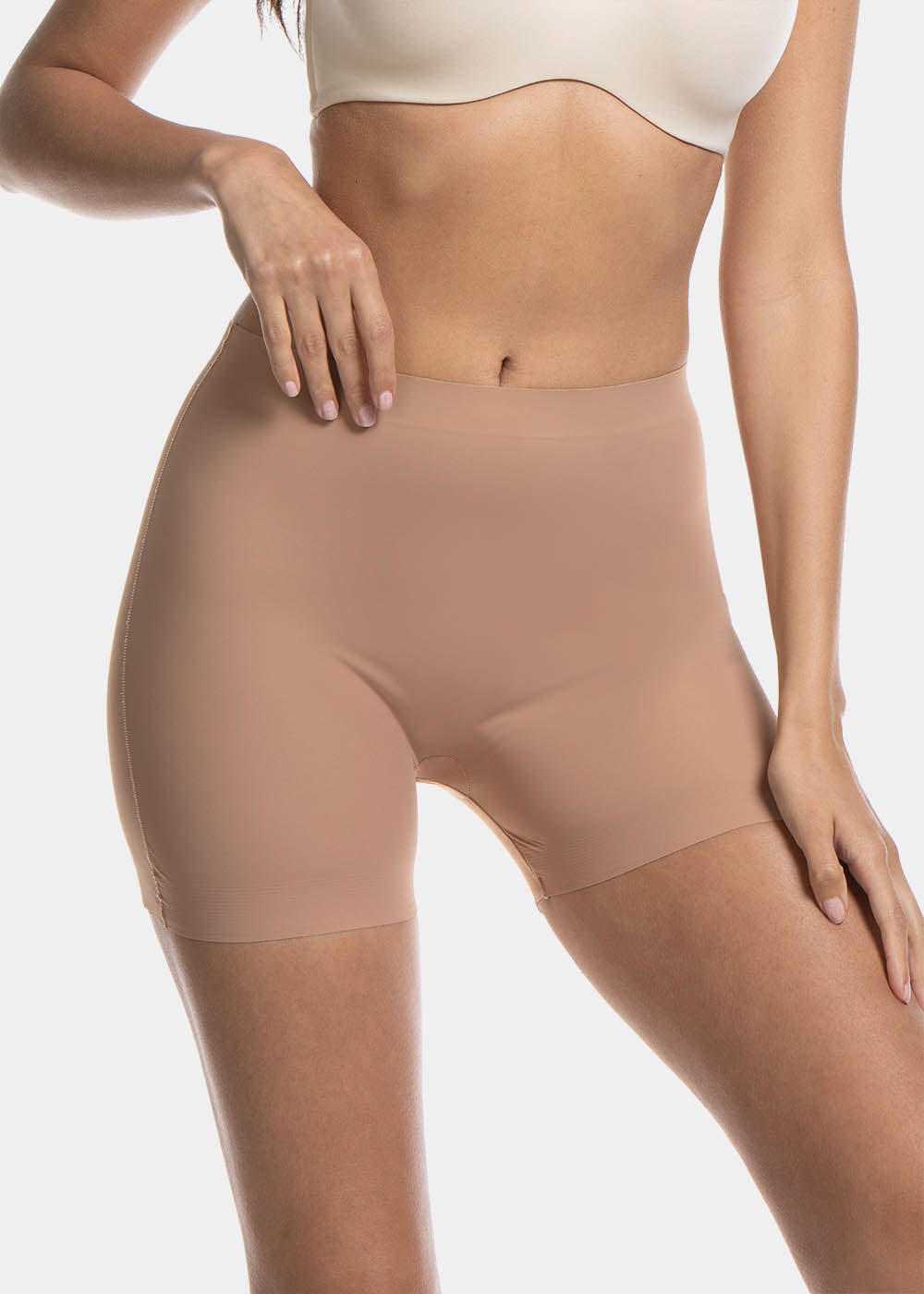 A woman wearing a black maxi sexy short that shapes the lower tummy, hips, and thighs. The short has silicone trim at the leg openings and a seamless edge for an invisible look.