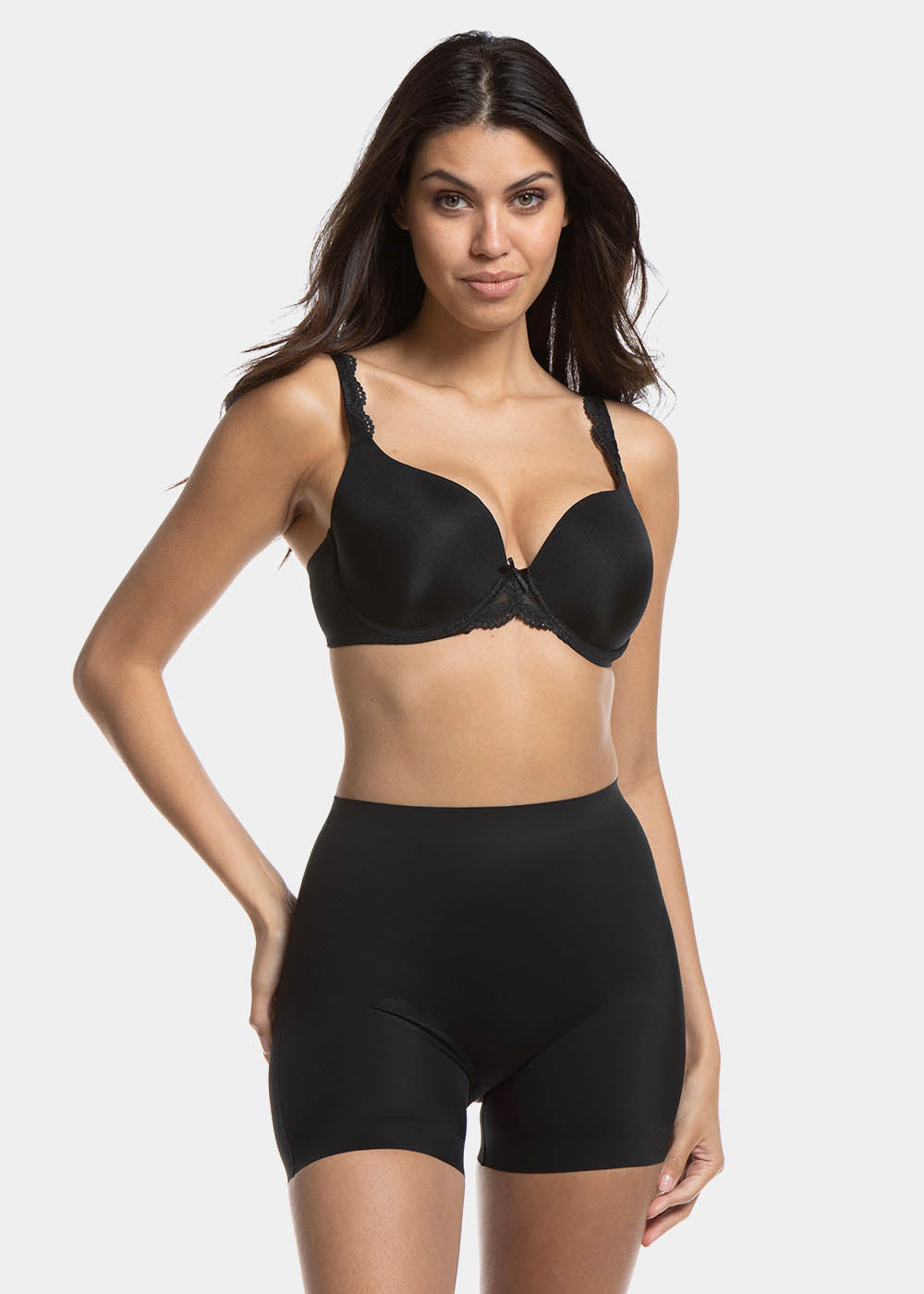 A woman wearing a black maxi sexy short that shapes the lower tummy, hips, and thighs. The short has silicone trim at the leg openings and a seamless edge for an invisible look.