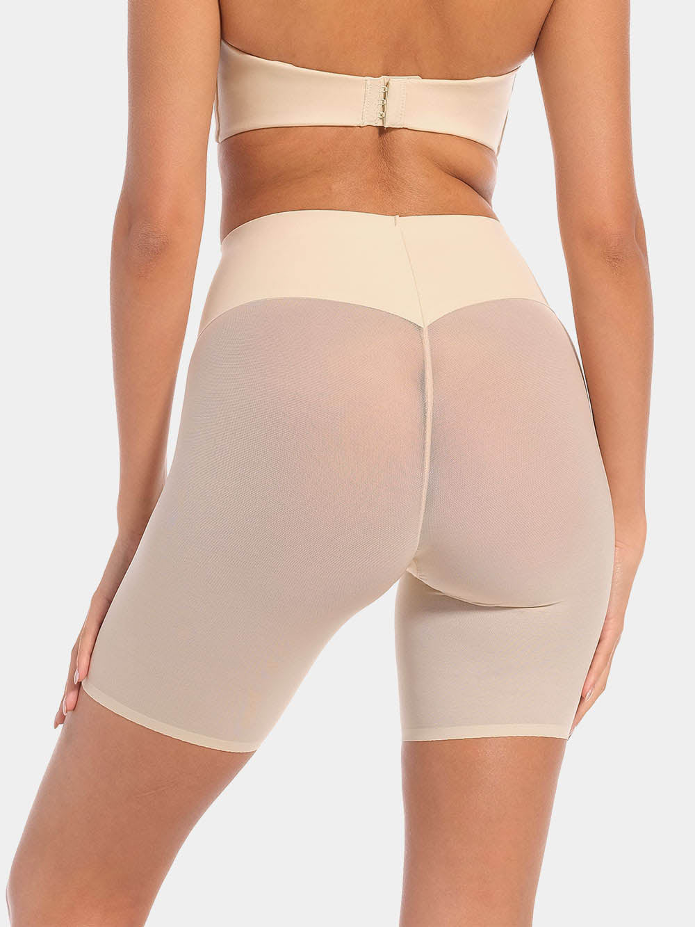 Back view of a model wearing Sheer & Sexy Shaping Short in latte, mid-waist shaping shorts. Smooth fabric with sheer mesh panels and special lift zone at the buttocks, featuring seamless edges for invisible wear.