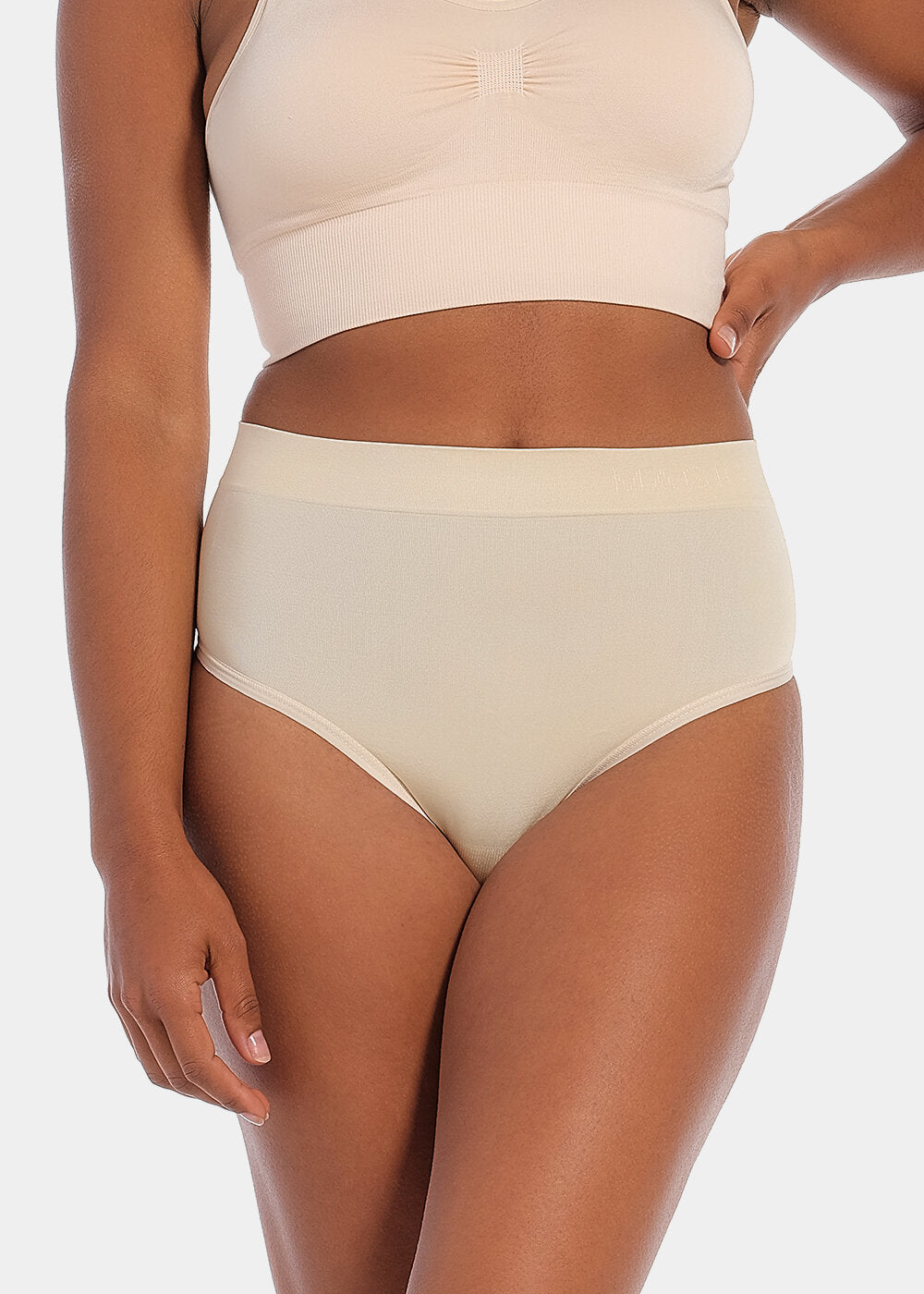 Front view of a model wearing the Comfort Thong, showcasing the soft, seamless fabric with light shaping through the lower tummy and a smooth, invisible finish under clothing.