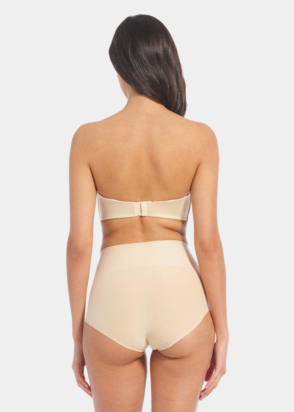 Back view of a model wearing Tummy Shaper in latte, mid-waist shaping brief with seamless design. Smooth fabric with full back coverage and invisible edges, providing firm shaping at the lower back.