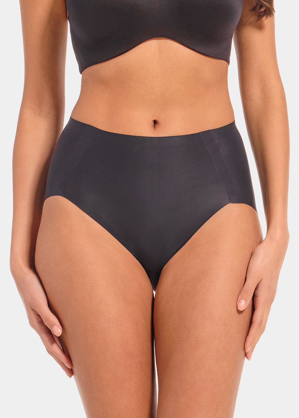 Back view of a model wearing Everyday Shaper Brief in black, mid-waisted seamless shapewear brief. Cropped image showing smooth fabric, seamless edges, and full back coverage designed for invisible shaping under clothing.