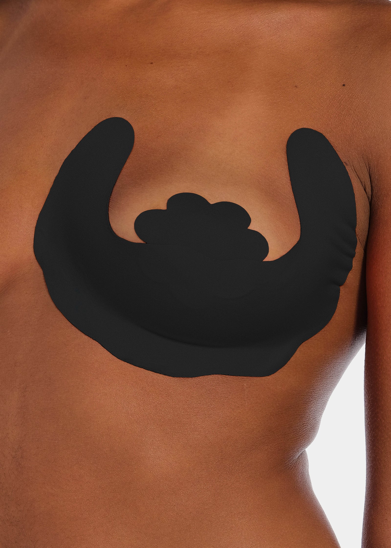 Front view of a model wearing the black Freedom Form adhesive breast lift strips, showcasing the strapless and backless design that lifts and supports the bust while remaining invisible under clothing.