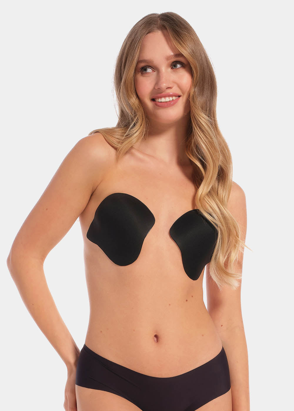 Front view of a model wearing the Ultimate Invisibles adhesive bra cups, showcasing the lightweight, backless and strapless design with two separate smooth cups that create natural-looking cleavage and an invisible finish under clothing.