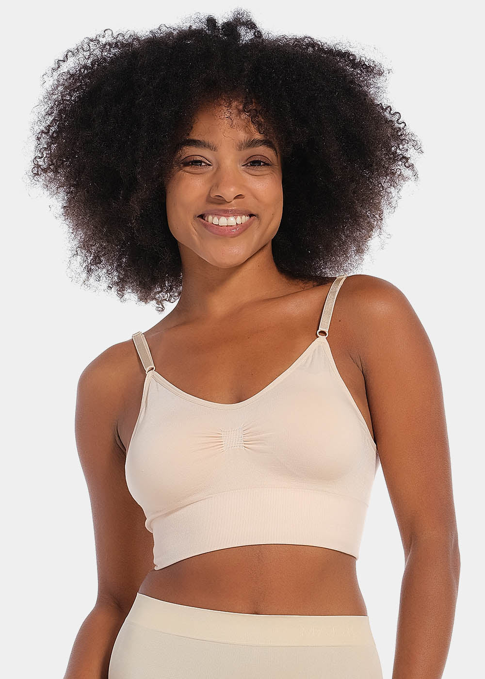 Front view of a model wearing the latte-colored Bamboo Low Back Bra, featuring a seamless, wireless design made from soft bamboo fabric. The bra includes built-in support, removable inlay pads for shaping, and adjustable spaghetti straps for a customized fit.