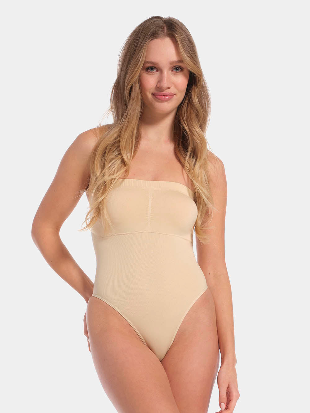 Front view of a model wearing the latte-colored Bandeau Thong Body, featuring a seamless, wireless bandeau design with built-in bust support, medium shaping through the waist and tummy, and a smooth, strapless silhouette.