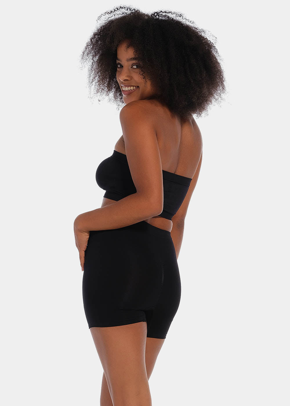 A person wearing a black comfort short that reaches mid-thigh, made of a smooth, solid fabric.
