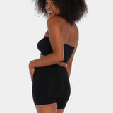 A person wearing a black comfort short that reaches mid-thigh, made of a smooth, solid fabric.