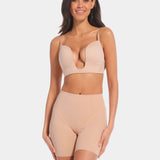 A person wearing a beige Dream Shaper Short that reaches mid-thigh, designed for shaping the lower back, tummy, and upper legs.