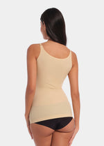 Back view of a model wearing Tone Your Body Cami in latte, body-contouring sleek cami. Smooth powerful recycled fabric providing firm shaping for lower back and waist, seamless edges, and adjustable spaghetti straps visible.