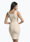 Back view of a model wearing Tone Your Body Dress in latte, body-contouring tank dress. Smooth powerful recycled fabric providing firm shaping for back, hips, and legs, with seamless edges, smooth shoulders, and silicone-lined leg openings visible.