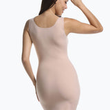 Back view of a model wearing Tone Your Body Dress in cappuccino, body-contouring tank dress. Smooth powerful recycled fabric providing firm shaping for back, hips, and legs, with seamless edges, smooth shoulders, and silicone-lined leg openings visible.