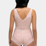 Woman wearing a beige bodysuit with lace details on a white background