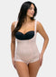 Woman wearing a black strapless top and beige shapewear on a white background