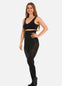 Front view of a model wearing Hi-Waist Slim Tights in black, 140 denier high-waist shaping tights. Smooth opaque fabric providing medium shaping for tummy, hips, and thighs, with silicone-trimmed waistband and reinforced toes visible.