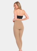 Back view of a model wearing Warm Fleece-Lined MAGIC Leggings in sunshine, high-waist fleece-lined leggings. Smooth fabric providing medium shaping for lower back and tummy, ladder-resistant finish, and translucent-look legs visible.