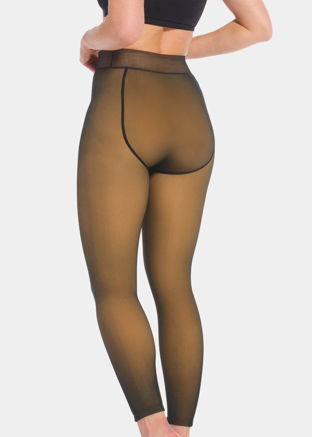 Front view of a model wearing Warm Fleece-Lined MAGIC Leggings in black, high-waist fleece-lined leggings. Smooth fabric providing medium shaping and tummy support, ladder-resistant finish, and translucent-look legs visible.