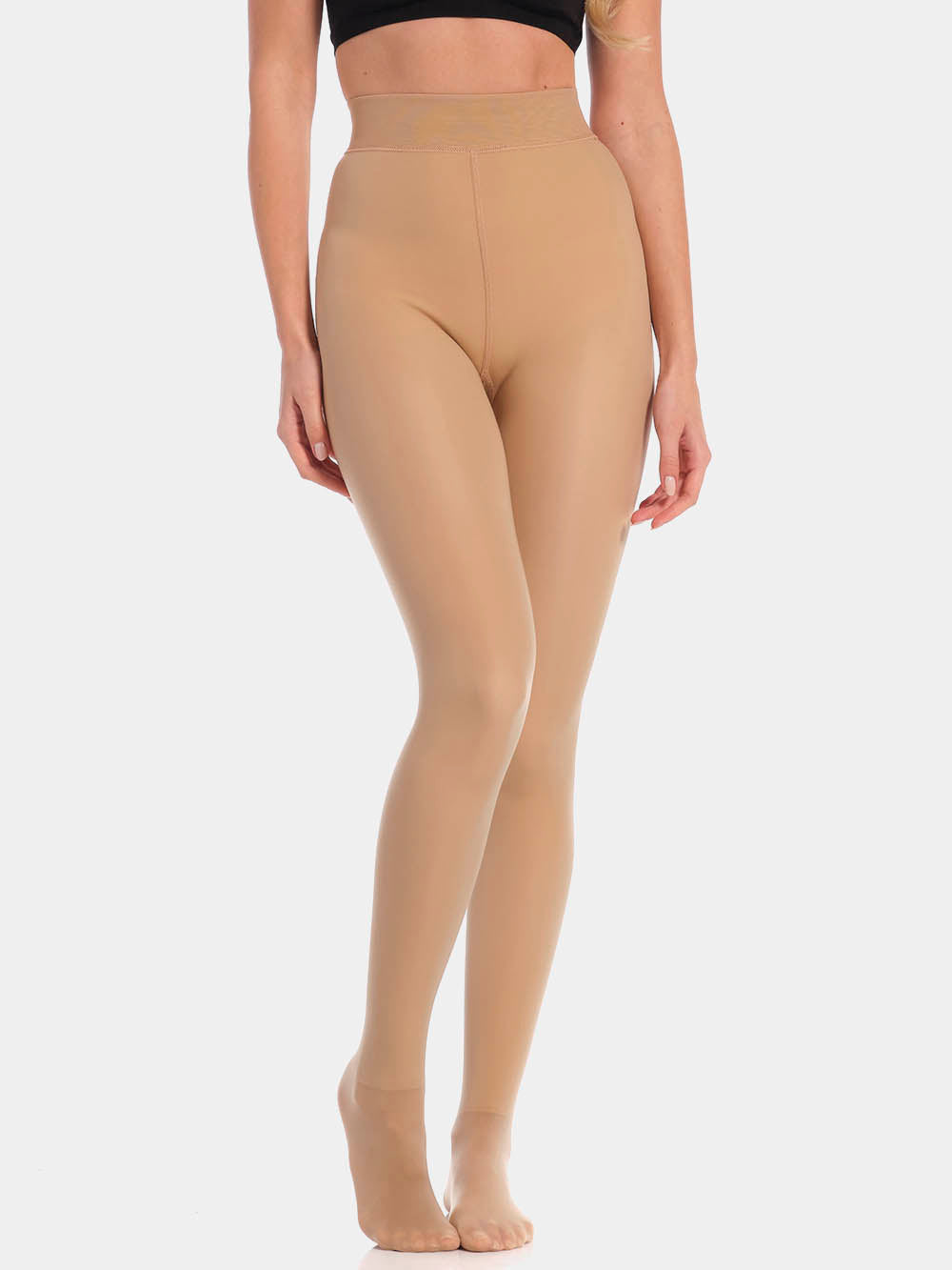Front view cropped image of a model wearing MAGIC Tights in latte, high-waist warm fleece-lined tights. Smooth fabric providing medium shaping for tummy and waist, ladder-resistant finish, and sheer-look legs with unfleece foot section visible.