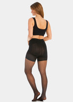 Back view of a model wearing Sexy Dots shaping tights in black, 20 denier sheer tights with dot pattern. Built-in firm shaping shorts providing control for lower back, hips, and upper legs, with subtle lift at the bottom and reinforced toes visible.