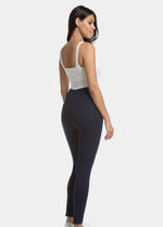 Back view of a model wearing Jegging in blue jeans, high-waist skinny-fit leggings with built-in shaping briefs. Soft stretchy fabric providing medium control for lower back and hips, lifted bottom zone, and functional back pockets visible.
