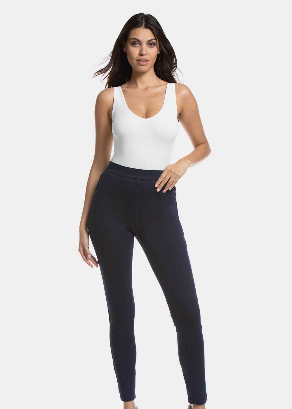 Front view of a model wearing Jegging in blue jeans, high-waist skinny-fit leggings with built-in shaping briefs. Soft stretchy fabric providing medium shaping for tummy, hips, and back, with cotton gusset, lifted bottom zone, and faux front pockets visible.