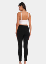 Back view of a model wearing Suedine Look Legging in black, high-rise leggings with built-in shaping briefs. Soft luxurious faux suede stretch fabric providing medium control for lower back and hips, with cotton gusset and smooth finish visible.