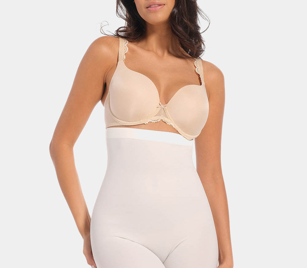 A woman wearing a high-waisted black shapewear Bermuda that extends to mid-thigh.