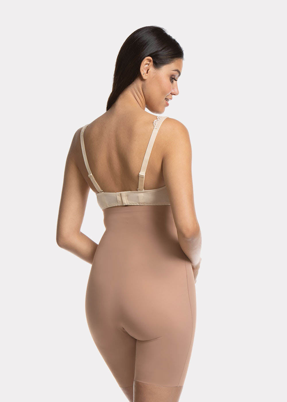 Back view of a model wearing Maxi Sexy Hi-Bermuda in mocha, high-waist mid-thigh shaping shorts. Smooth powerful fabric with firm control for lower back, hips, and thighs, seamless edges, and silicone-trimmed waistband visible.