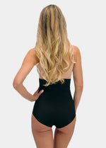 Woman wearing a black hi-brief against a white background