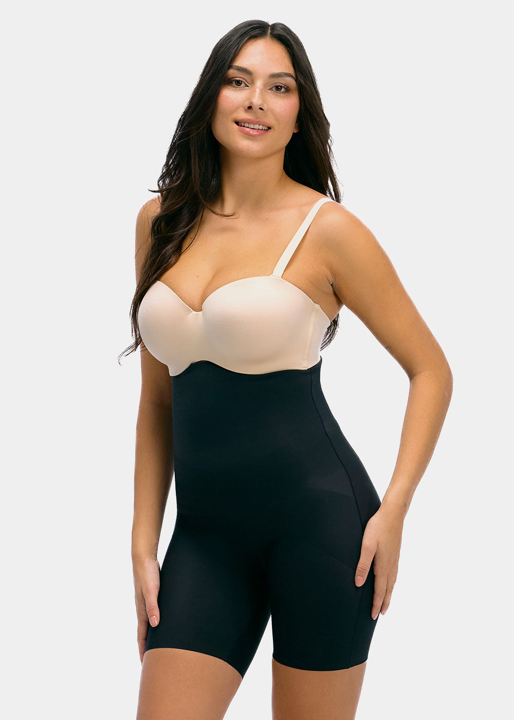 Woman wearing a black shapewear Hi-Bermuda with a beige bra on a white background