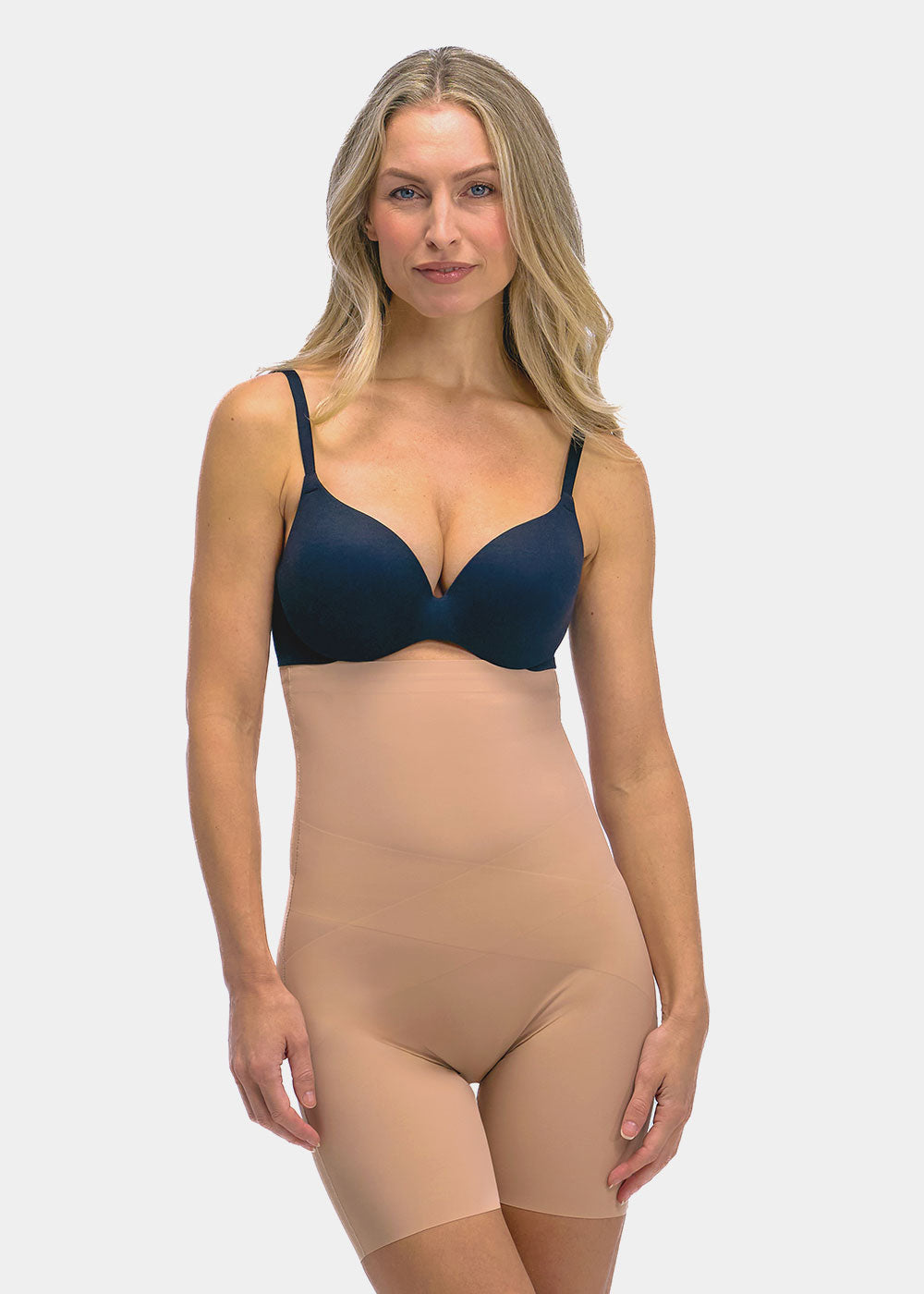 Woman wearing a navy bra and beige shapewear Hi-Bermuda on a white background