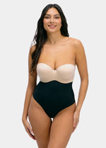 Woman wearing a strapless top and high-waisted black  thong on a white background