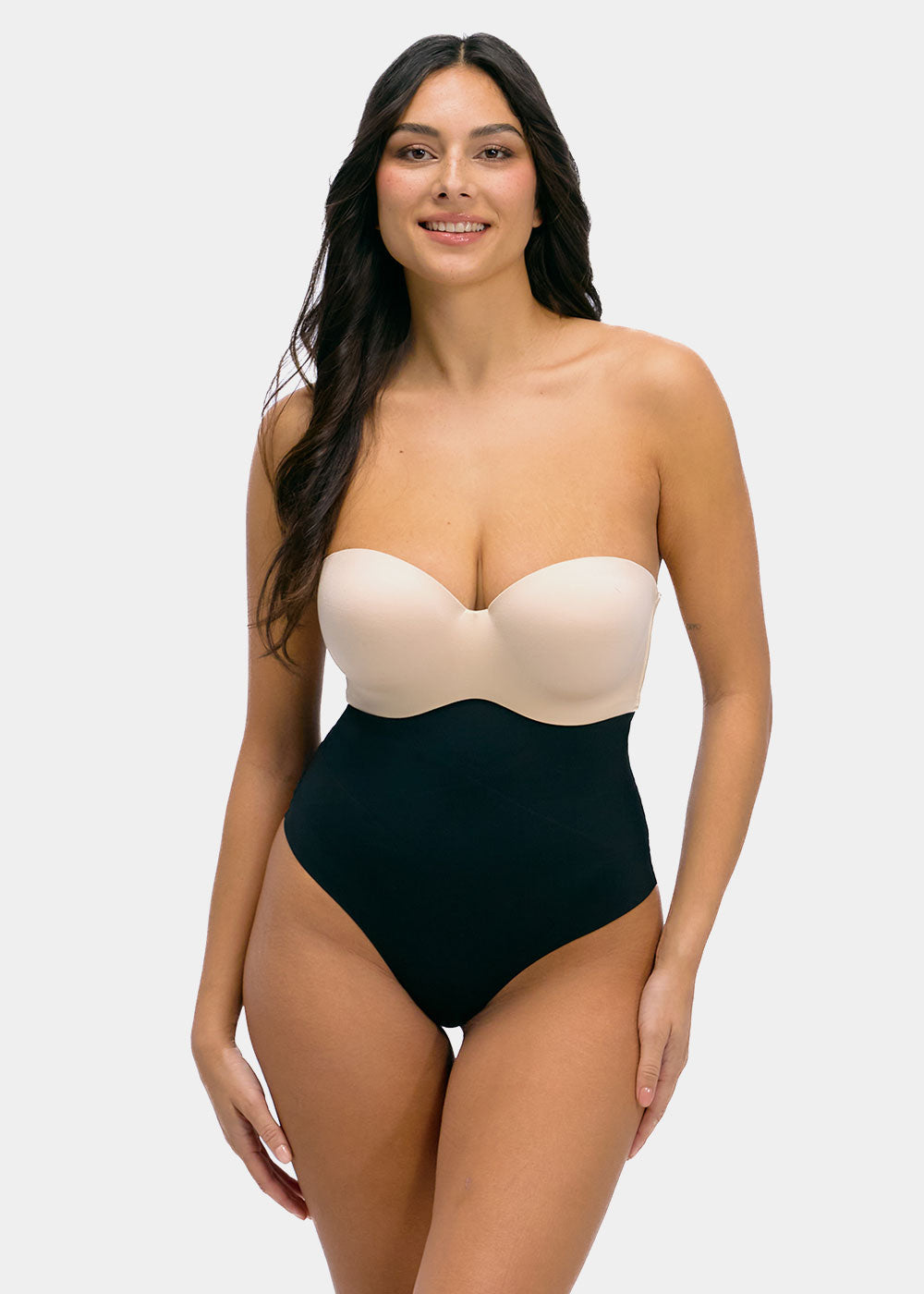 Woman wearing a strapless top and high-waisted black  thong on a white background