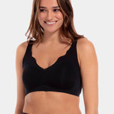 A woman wearing a black Sensual Bra with mesh details at the cups and straps, and a hook-and-eye back closure.