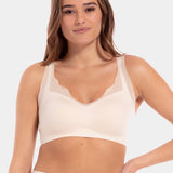 A woman wearing a white Sensual Bra with mesh details at the cups and straps, and a hook-and-eye back closure.
