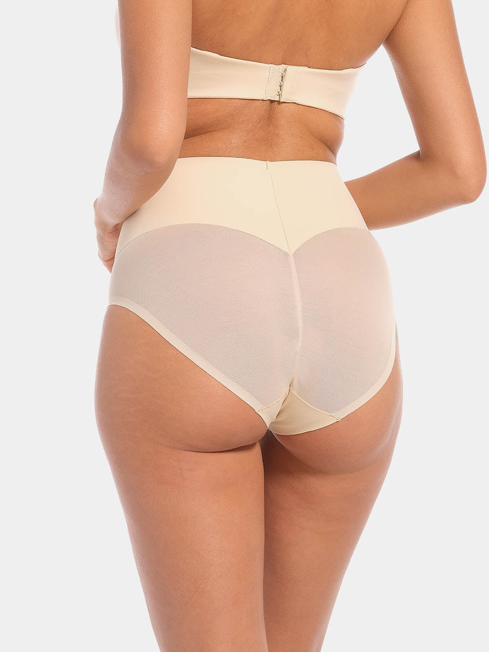 Back view of a model wearing Sheer & Sexy Brief in latte, mid-waist shaping brief. Smooth fabric with sheer mesh panels and special lift zone at the buttocks, featuring seamless edges for invisible wear.