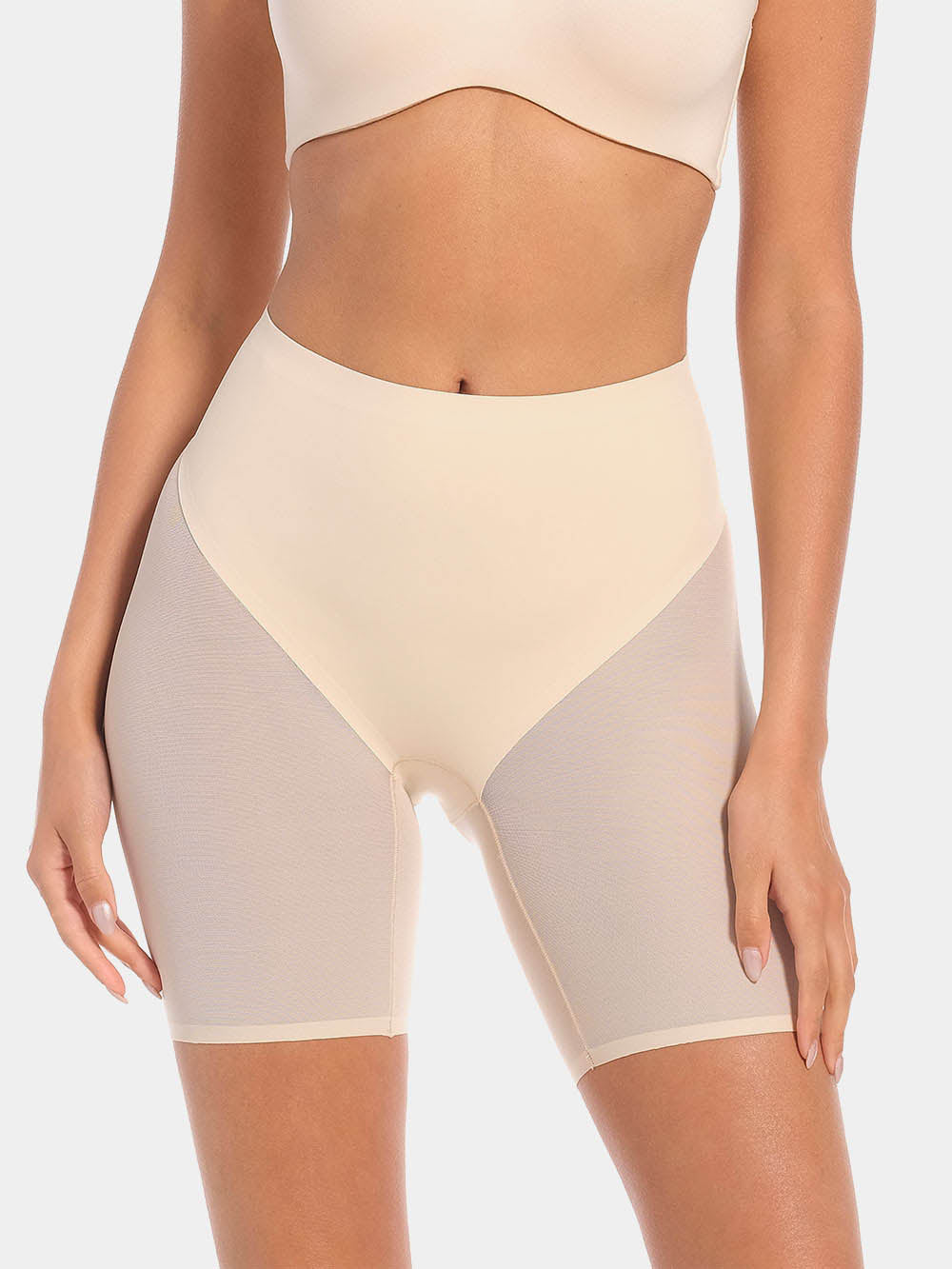 Front view of a model wearing Sheer & Sexy Shaping Short in latte, mid-waist shaping shorts. Smooth fabric with sheer mesh panels, medium shaping for tummy and lower back, and special lift zone at the buttocks visible.