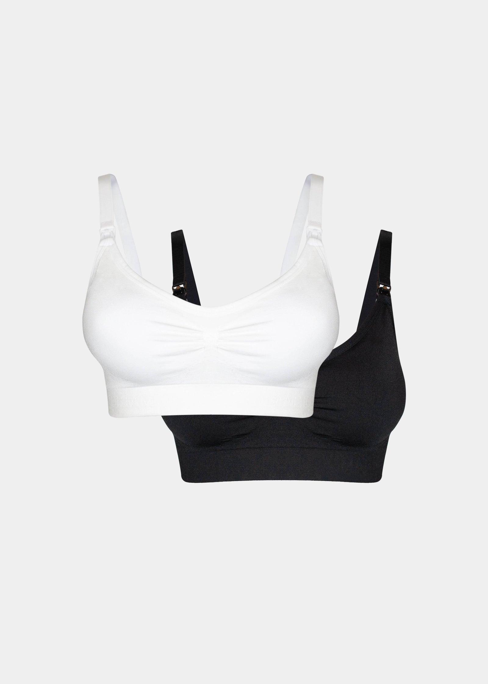 Still product image of Mama Comfort Nursing Bra in white and black, seamless wire-free nursing bras. Two bras shown flat with adjustable straps, clip-down cups, and smooth stretchable fabric visible.