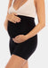 Front view of a model wearing Mama Supporting Short in black, over-the-bump seamless maternity shapewear shorts. Smooth stretchable fabric with mid-thigh length and supportive belly panel, designed for support and invisible wear under clothing.