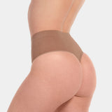 Back view of a model wearing the Macchiato-colored Comfort Thong, featuring soft, seamless fabric with a smooth, minimal design and an invisible finish that enhances the natural shape.