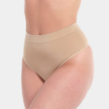 Front view of a model wearing the cappuccino-colored Comfort Thong, featuring soft, seamless fabric with light shaping support and a smooth, invisible finish under clothing.