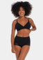 Black mid-waist shaping brief worn by a model in a front-facing standing position, featuring firm lower tummy and back shaping with built-in powernet support, smooth strong breathable fabric, flat invisible lace, and cotton gusset lining.